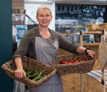 lady showing of fresh produce in a farm shop